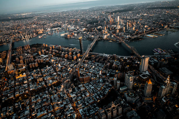 Golden hour aerial view of Brooklyn Bridge, Manhattan Bridge, and Williamsburg Bridge reaching from Brooklyn to Manhattan, NYC, taken from a helicopter over Lower Manhattan island Brooklyn Bridge, Manhattan Bridge, and Williamsburg Bridge captured from air over the Lower Manhattan at dusk. brooklyn new york stock pictures, royalty-free photos & images