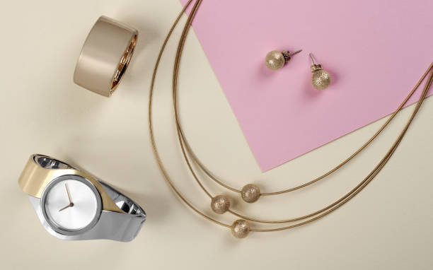 gyllene smycken set armbandsur på papper bakgrund - earring above bildbanksfoton och bilder
