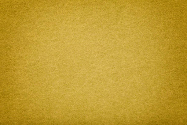 Golden matt suede fabric closeup. Velvet texture. Light yellow matte background of suede fabric, closeup. Velvet texture of seamless golden leather with vignette. Felt materisl macro. matte finish stock pictures, royalty-free photos & images
