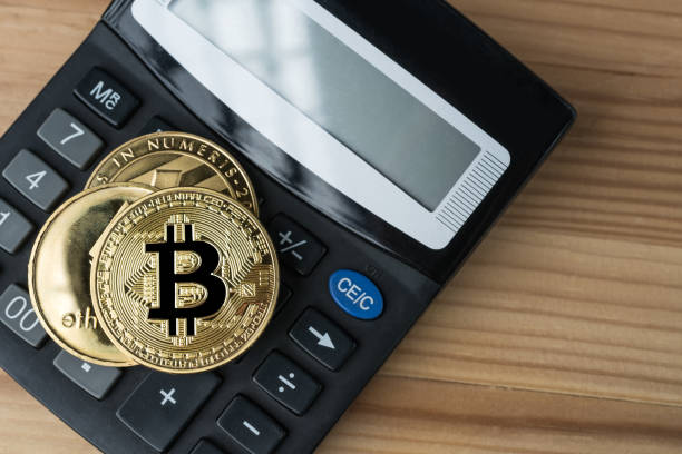 Golden physical Bitcoin, Ethereum and Litecoins on calculator. Gdansk, Poland - 17 September 2018: Golden physical Bitcoin, Ethereum and Litecoins on calculator on wooden background. Cryptocurrency market numbers abstract concept. With Ethereum stock pictures, royalty-free photos & images