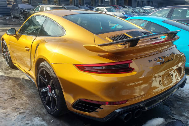 Golden Porsche 911 Turbo S Exclusive series. Limited edition. Number three hundred thirty seven. In the world were produced only 500 cars.  Back side view stock photo