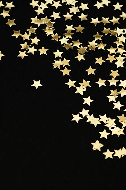 Golden stars falling from the top on black background stock photo