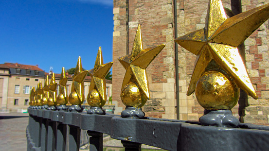 Golden start detail in the fence of Basilica of Saint Sernin, Toulouse, France during summer. World Heritage Site. Tourism landmark in Europe.
