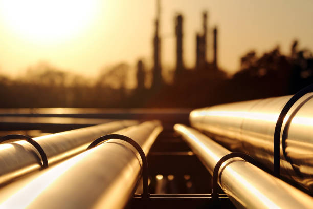 gouden zonsondergang in ruwe olieraffinaderij met pijpleidingsysteem - gas stockfoto's en -beelden