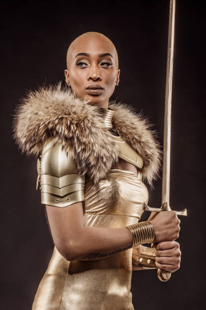 Golden viking inspired warrior female in studio shot Golden viking inspired black warrior female in studio shot armored clothing stock pictures, royalty-free photos & images