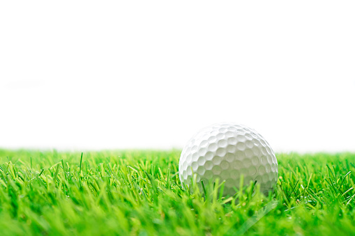Golf ball and artificial grass on the white background.