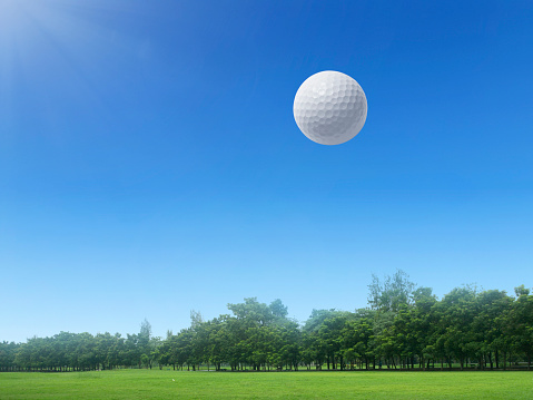 Golf ball floating in the air on a golf course