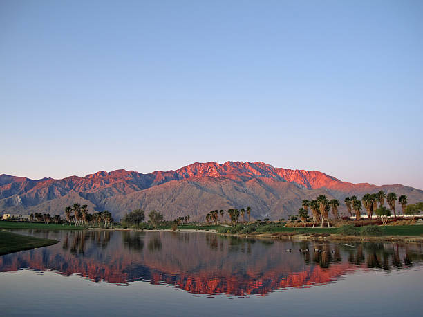Golf course at dawn with sunrise kissed mountains stock photo