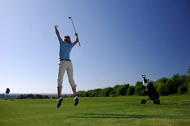 Golf player on course jumping and celebrating stock photo