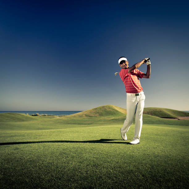 Golfer swinging stock photo