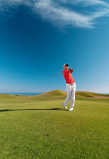 Golfer swinging stock photo