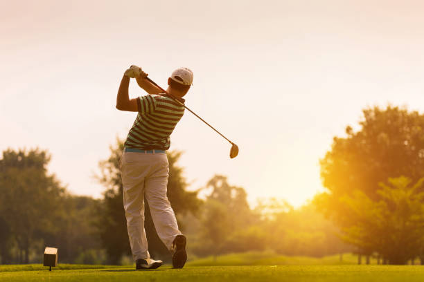 Golfers hit sweeping golf course in the summer stock photo