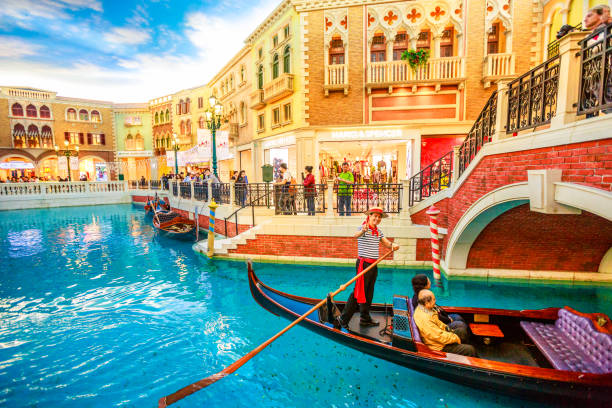 Gondola Ride Venetian Macao Macau, China - December 9, 2016: gondolier on famous italian gondola with tourists on a romantic ride on the canals of the Venetian Luxury Hotel and Casino and mall. the venetian macao stock pictures, royalty-free photos & images