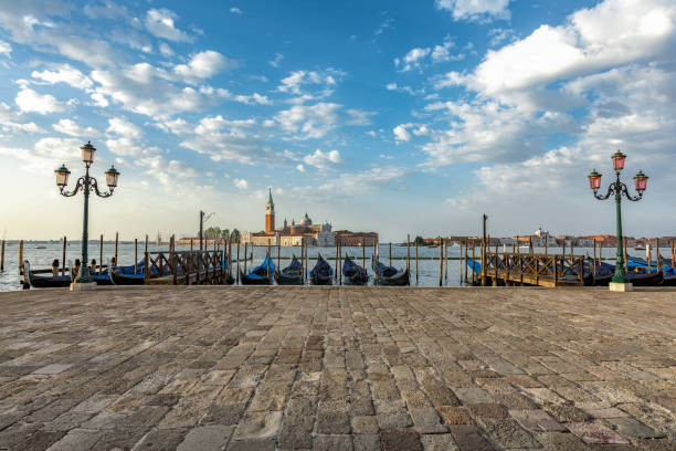 Gondolas moored by Saint Mark square with San Giorgio di Maggiore church in Venice, Italy stock photo