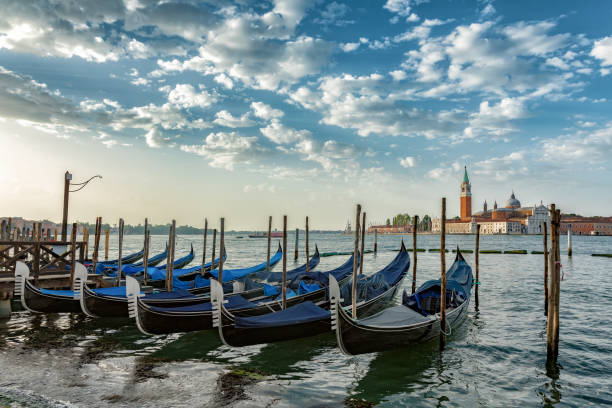 Gondolas moored by Saint Mark square with San Giorgio di Maggiore church in Venice, Italy stock photo