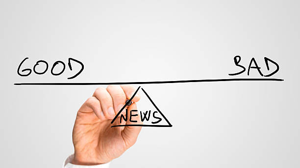 Good and bad news Male hand drawing seesaw showing Good and Bad news in perfect equilibrium. good news stock pictures, royalty-free photos & images