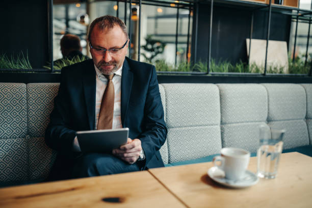 Good coffee and wireless connection Mature businessman holding a tablet Portable DVD Player stock pictures, royalty-free photos & images