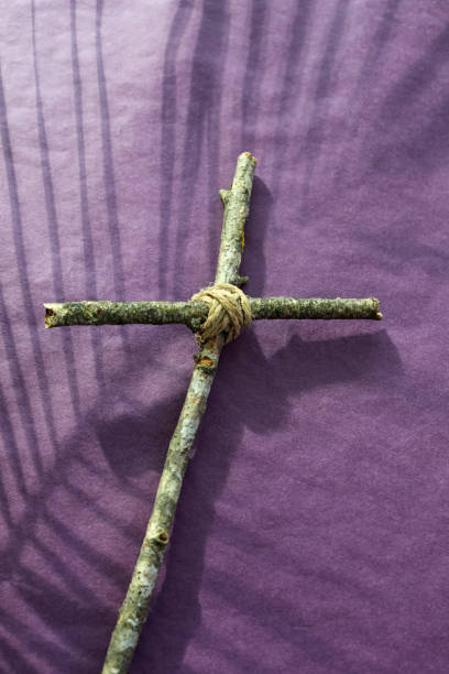 concept du vendredi saint, du carême et de la semaine sainte. une croix chrétienne et une ombre de feuille de palmier sur fond violet. - good friday photos et images de collection