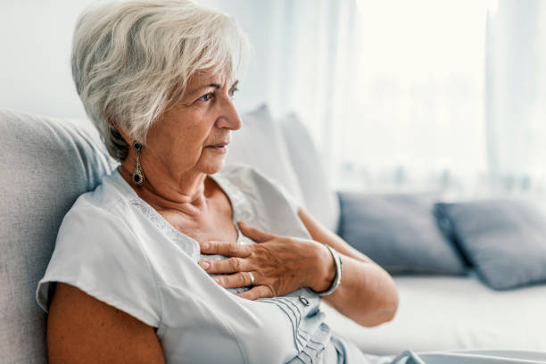 snygg äldre kvinna få hjärtattack - medelålders kvinna bröstsmärtor bildbanksfoton och bilder