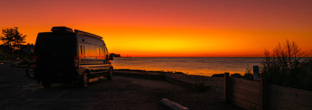 Good Morning Cape Cod. Red and orange colored sunrise at the beach with the view of a mobile home park. stock photo