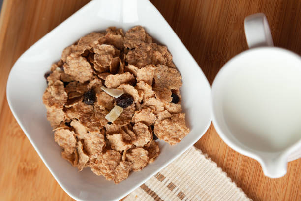 Good start to the day to have the right meal, healthy breakfast in bed with cornflakes and dried fruits and milk. stock photo