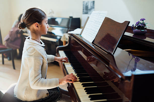 good student plays  piano at a music school stock photo