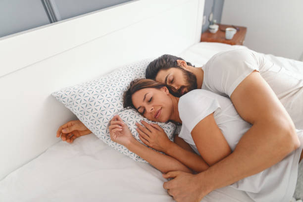 gorgeous couple sleeping in bedroom. man hugging his loving wife. morning time. - sleeping couple imagens e fotografias de stock