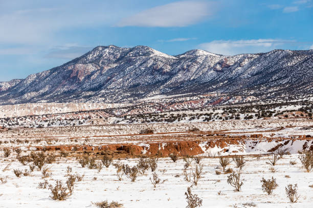 Gorgeous rolling mountain range with red rock canyon and snow in rural New Mexico stock photo