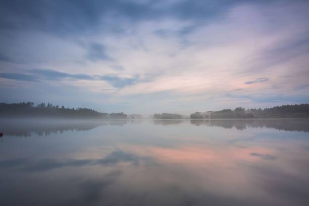 vacker utsikt över dimman vid solnedgången på sjön under sommar dagen. vita moln på blå himmel. europa. sverige. underbara bakgrunder. - nature sweden bildbanksfoton och bilder