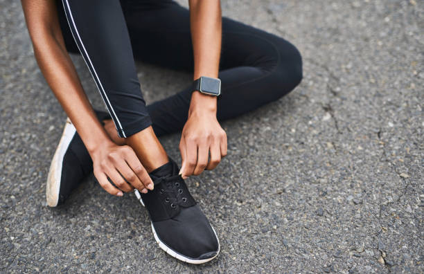 Got to get them tight Closeup shot of a sporty woman tying her shoelaces while exercising outdoors sports shoe stock pictures, royalty-free photos & images
