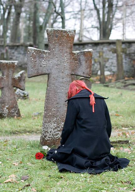 Gothic girl with a rose on cemetery stock photo