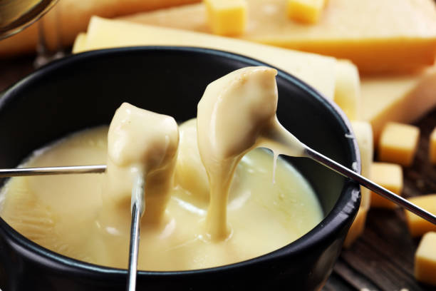 Gourmet Swiss fondue dinner on a winter evening with assorted cheese stock photo