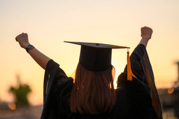 Graduates wear a black dress, black hat at the university level. stock photo