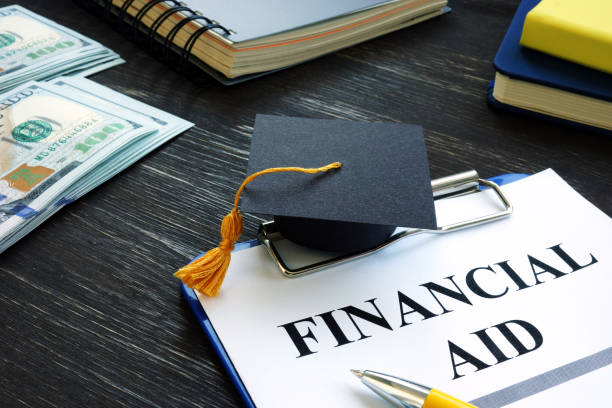 Graduation cap and financial aid for student form. Graduation cap and financial aid for student form on the desk. Debt Consolidation stock pictures, royalty-free photos & images