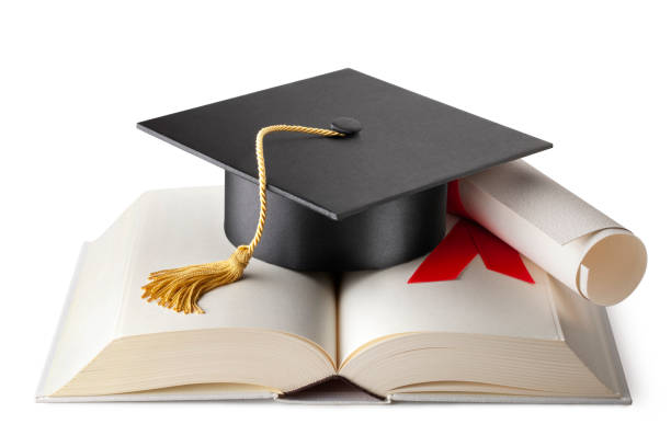 Graduation cap on book with diploma Graduation cap on book with diploma isolated on white background. bachelor degrees stock pictures, royalty-free photos & images
