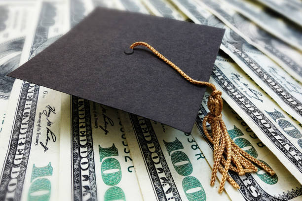 Graduation cap on money stock photo