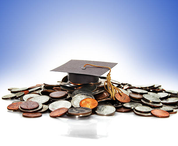 Graduation cap graduation cap  on a pile of money ( student debt ) student debt stock pictures, royalty-free photos & images