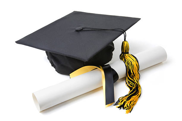 Graduation cap with a tassel and a rolled diploma stock photo