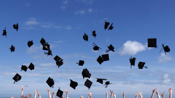 Graduation celebrations, throwing caps into a blue sky A Group of Graduates celebrating the award of their university or college degrees student loan stock pictures, royalty-free photos & images