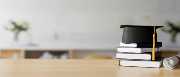 Graduation concept, 3D rendering, graduation cap on stack of books on the table with copy space and blurred background stock photo