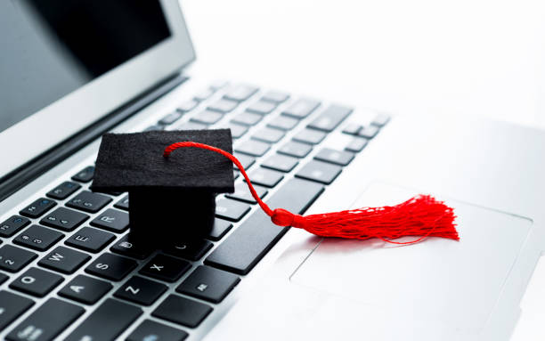 Graduation hat on computer keyboard Graduation hat on computer keyboard computer science degree online stock pictures, royalty-free photos & images