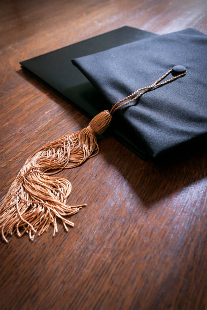 Graduation mortarboard cap and diploma stock photo