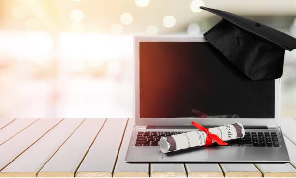 Graduation. Laptop and diploma scroll on background degree online stock pictures, royalty-free photos & images