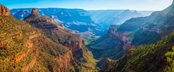 Grand Canyon Bright Angel Trail Indian Garden Plateau Point panorama Panoramic vista down the Bright Angel Trail to the green oasis of Indian Garden and the early morning rays of sunlight illuminating the North Rim of the Grand Canyon National Park, Arizona, USA. south rim stock pictures, royalty-free photos & images