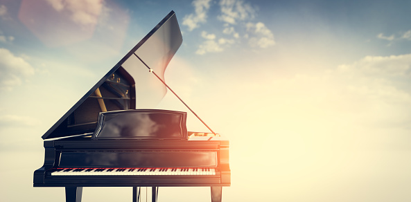 Classic grand piano on sunset sky background. Music and entertainment