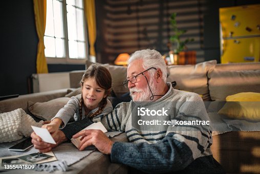 istock Grandad showing her granddaughter memories from past 1355441809