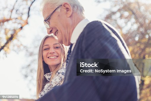 istock Granddaughter and grandfather walking in the park 941285014