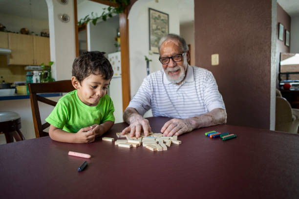 grandfather and grandson playing at home stock photo
