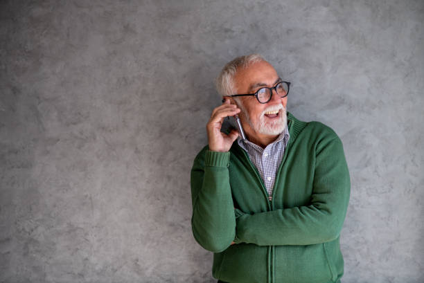 Grandfather with eyeglasses talks on phone. Copy- space. stock photo