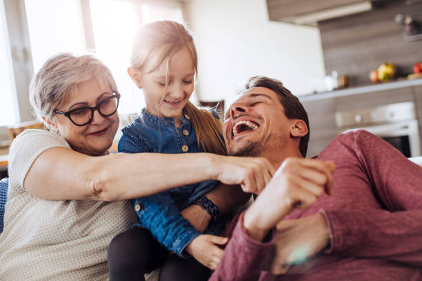 Grandma playing with granddaughter and son Grandma playing with granddaughter and son on sofa. tickling beautiful women pictures stock pictures, royalty-free photos & images